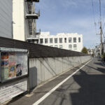 ⑩我が家の方角から見たトプコン。この道も拡幅され、住宅も増えた