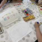 ③1階101の「結まつりボランティアし隊」のブース。「案内板のぬり絵作成」に子どもたちが挑戦